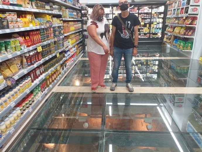 La portavoz de UP-IU en el Ayuntamiento de Huelva en el establecimiento bajo el que se encuentran los restos de la muralla prerromana de la capital.