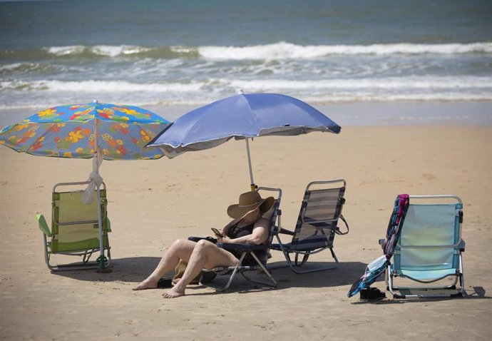 Archivo - Una mujer toma el sol en la playa de Matalascañas en una imagen de archivo.