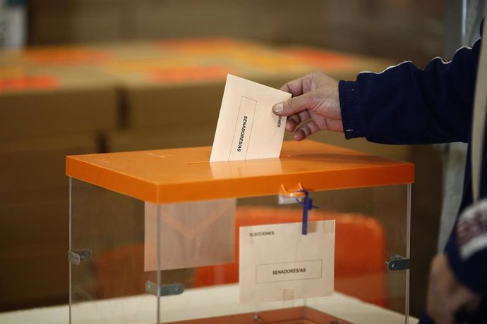 Archivo - Papeleta y sobre en la urna de votación