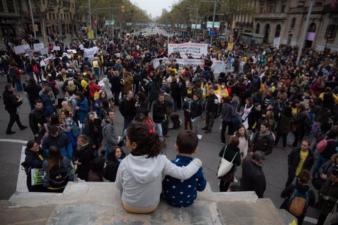 Archivo - Dos niños se manifiestan subidos a un muro mientras otros manifestantes cortan Jardinets de Grcia con Avenida Diagonal, como parte de las movilizaciones por la huelga educativa (Archivo)