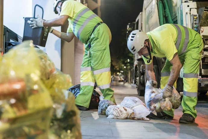 Trabajadores municipales recogiendo bolsas de recogida selectiva. - Archivo