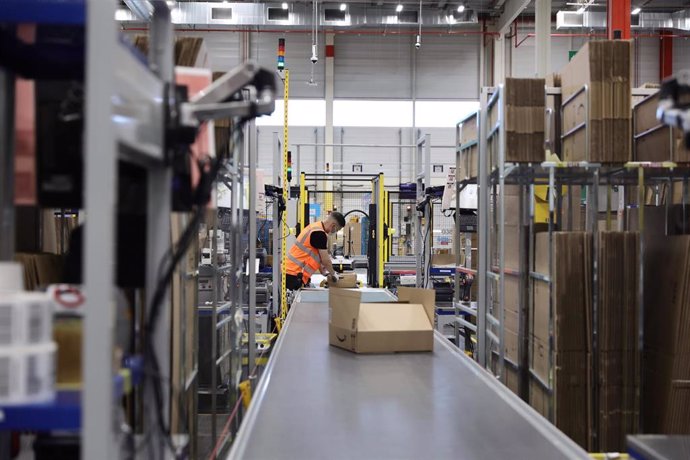 Archivo - Un trabajador empaqueta en cajas de cartón pedidos para enviar, en el interior de las instalaciones del Centro Logístico de Amazon en Alcalá de Henares