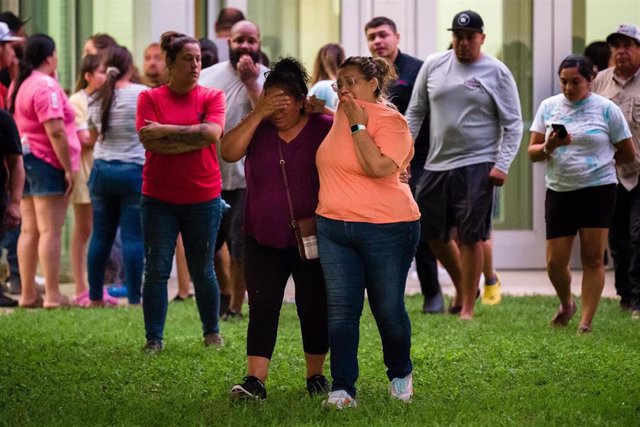 Dos mujeres esperan noticias de lo ocurrido en la escuela primaria de Uvalde, Texas, después de que un joven asesinara a 21 personas, 19 de ellas niños.