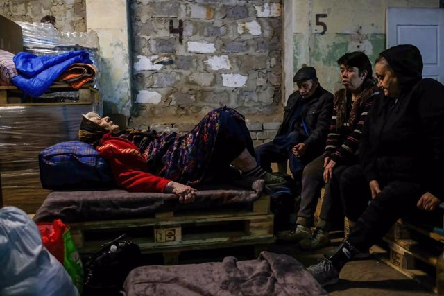 Una mujer herida yace sobre un palé de madera dentro del centro de distribución de ayuda humanitaria de la ciudad de Severodonetsk
