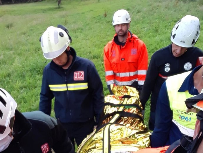 Momento del rescate y traslado a la ambulancia del hombre que cayó en una zona de maleza en San Miguel de Meruelo.
