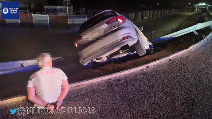 El arrestado junto a su vehículo, tras colisionar contra un quitamiedos