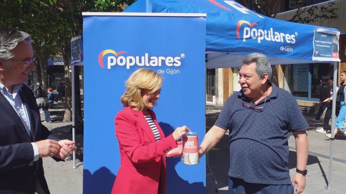 La presidenta del PP de Asturias, María Teresa Mallada, paricipa con un donativo en la  campaña '1 para recuperar El Muro",en Gijón, acompañada del presidente del PP gijonés, Pablo González