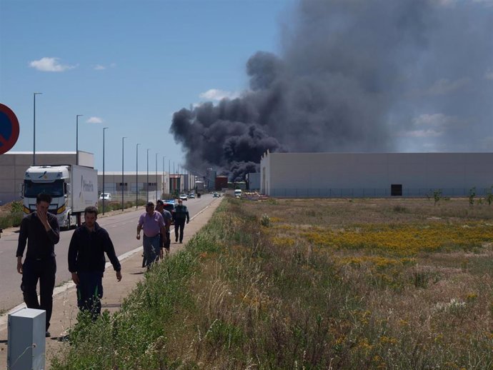 Varias personas delante de una nube negra de humo generada por la explosión en una planta biodiesel de Calahorra, a 26 de mayo de 2022, en Calahorra, La Rioja (España). 