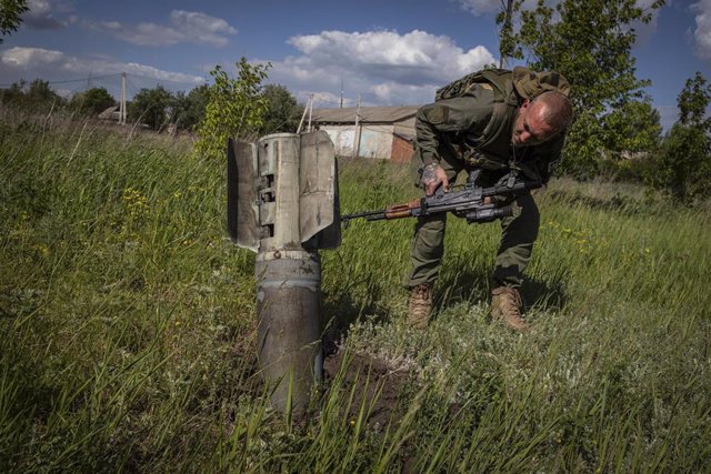 Soldado ucraniano junto a un misil ruso sin detonar