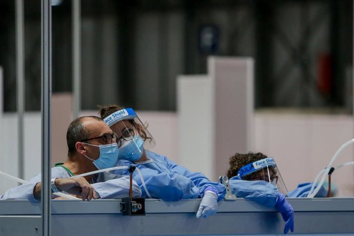 Archivo - Una sanitaria protegida con mascarilla, guantes y pantalla protectora y un paciente