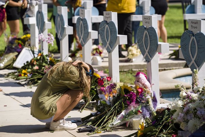26 May 2022, US, Uvalde: Elena Mendoza grieves for her cousin Amerie Jo Garza at the memorial for victims of the Robb Elementary School shooting. An 18-year-old had broken into the school and opened fire on children and adults. At least 19 children died