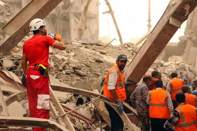 Miembros de los equipos de rescate tras el derrumbe de un centro comercial en la ciudad de Abadán, en Irán