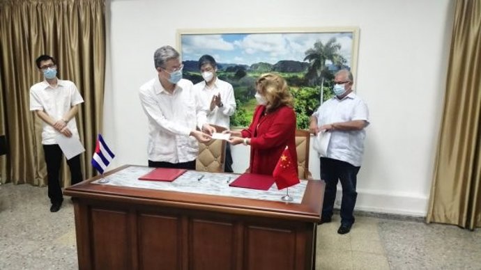 El embajador chino en Cuba, Ma Hui, da un cheque a la ministra de Comercio Exterior de Cuba, Déborah Rivas