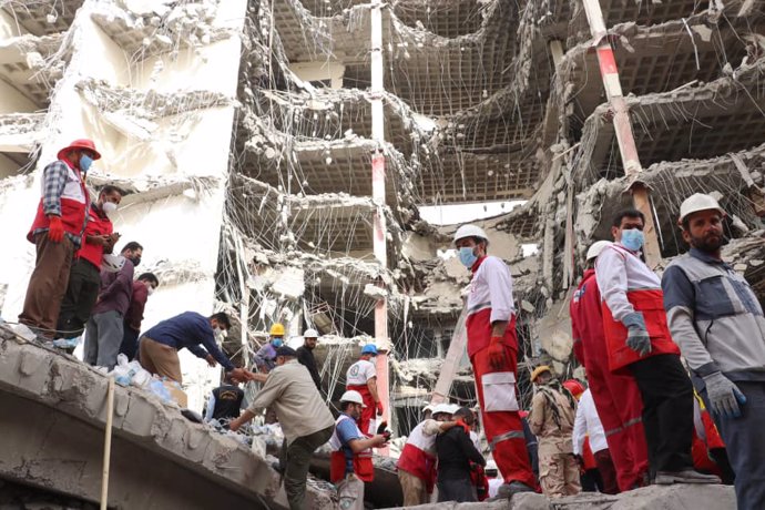 FILED - 26 May 2022, Iran, Abadan: Rescue workers and members of Red Crescent work at the site where a ten-storey under-construction building collapsed in the city of Abadan. Several people were killed and many injured in the collapse of the ten-story b