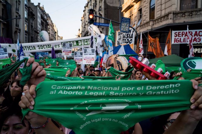 Archivo - Una mujer sostiene un pañuelo verde en una movilización a favor de la legalización del aborto en Argentina