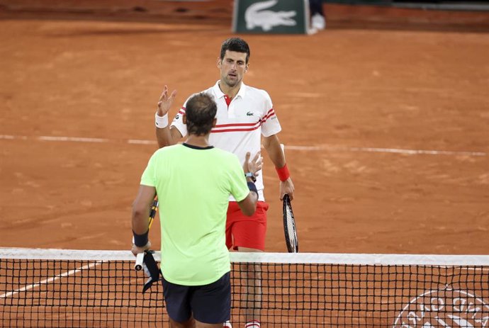 Archivo - Novak Djokovic estrecha la mano de Rafa Nadal tras derrotarle en las semifinales de Roland Garros 2021