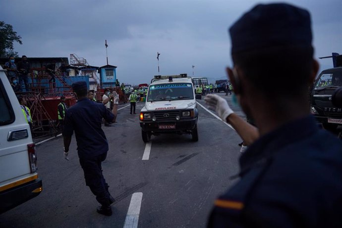 Personal de seguridad de Nepal traslada el cuerpo de una de las víctimas del accidente aéreo en Sanosware