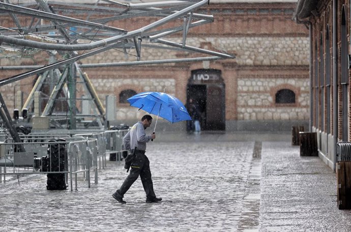 Una persona camina con paraguas el día en que han puesto en aviso amarillo a la Comunidad de Madrid por tormentas y lluvias, a 2 de mayo de 2022, en Madrid (España). La bajada de temperaturas para este 2 de mayo de manera generalizada en España ha provo