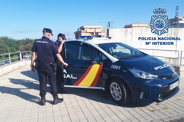 Agentes de la Policía Nacional junto a un vehículo del cuerpo.