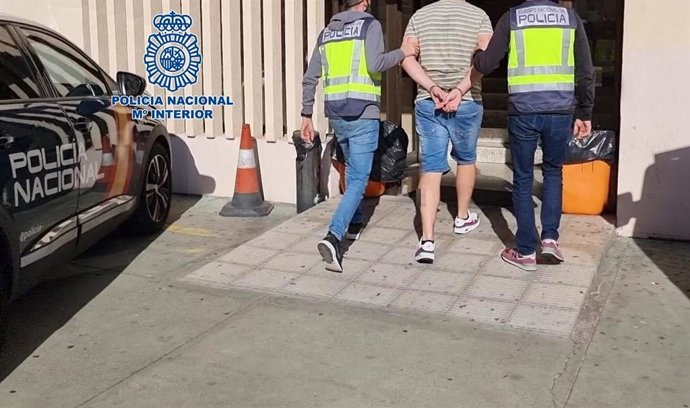 Archivo - Agentes de la Policía Nacional junto al detenido