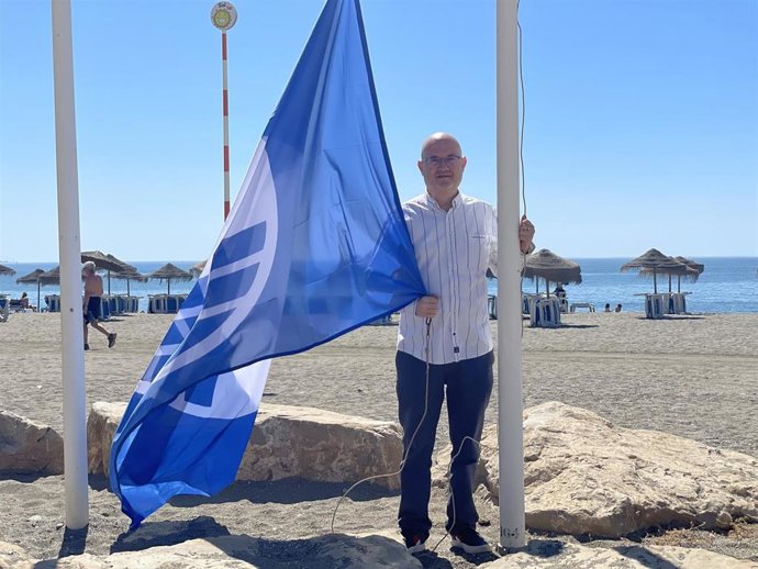 Jesús Pérez Atencia, concejal de Playas de Vélez-Málaga, iza una bandera azul en una de las playas de su litoral
