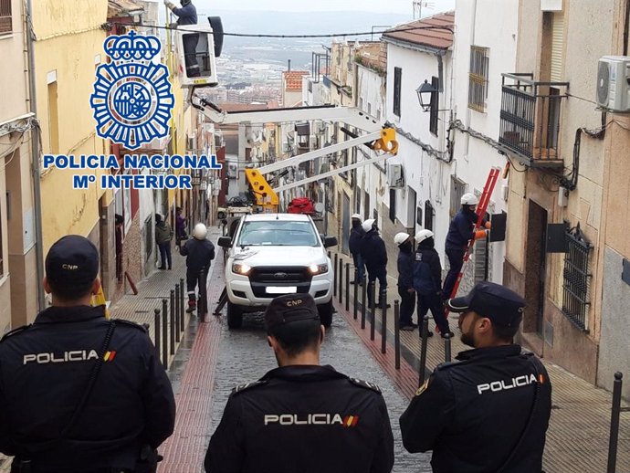 Archivo - Policías supervisan a técnicos de Endesa en trabajos contra los enganches ilegales al suministro eléctrico en una imagen de archivo