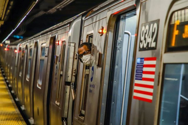 Archivo - 08 April 2020, US, New York: A New York metro passenger wearing a protective mask looks out from a window, amid the Coronavirus (Covid-19) pandemic in the United States.