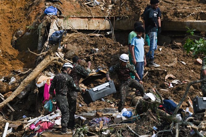 Archivo - 17 February 2022, Brazil, Petropolis: Rescue workers and residents search for victims in an area affected by landslides in Petropolis. The death toll in the mountainous region of the Brazilian state of Rio de Janeiro has risen to more than 100