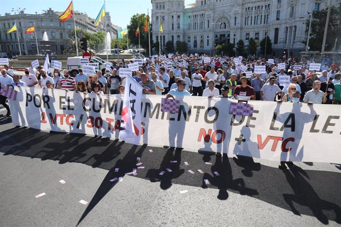 Varias personas sujetan una pancarta en la que se lee: 'Por el cumplimiento de la ley 1 VTC/ 30 taxis, no + VTC', durante una marcha contra la reforma de la Ley de Transportes.