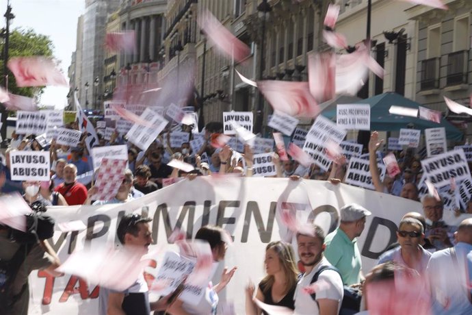 Manifestantes lanzan billetes al aire durante una marcha contra la reforma de la Ley de Transportes, a 1 de junio de 2022, en Madrid (España). La Federación Profesional del Taxi de Madrid (FPTM) ha convocado para hoy esta manifestación que recorrerá "la