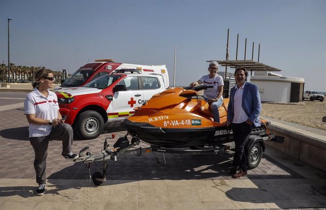 El concejal de Playas en València, Giuseppe Grezzi (d), y miembros de Cruz Roja presentan el dispositivo de salvamento y socorrismo que presta esta entidad en la costa de la ciudad durante el verano. 