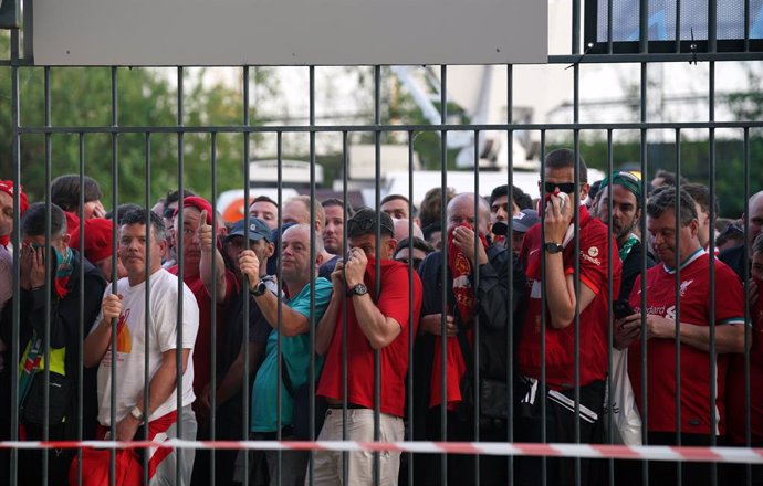 28 May 2022, France, Paris: Liverpool fans cover their mouths and noses as they queue to gain entry to the stadium ahead of the UEFA Champions League final soccer match between Liverpool FC and Real Madrid CF at the Stade de France. Photo: Peter Byrne/P