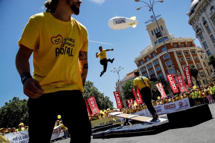 Una persona salta desde un trampolín durante una manifestación de sindicatos mayoritarios en Correos, a 1 de junio de 2022, en Madrid (España)
