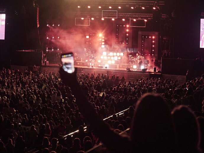 Archivo - Una persona graba a la cantante Aitana durante un concierto (archivo)