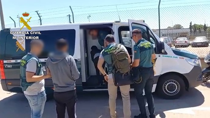 Uno de los detenidos escoltados por agentes de la Guardia Civil.