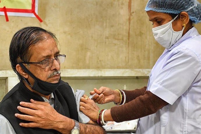 Archivo - Personal sanitario inocula a un ciudadano en Calcuta, India.