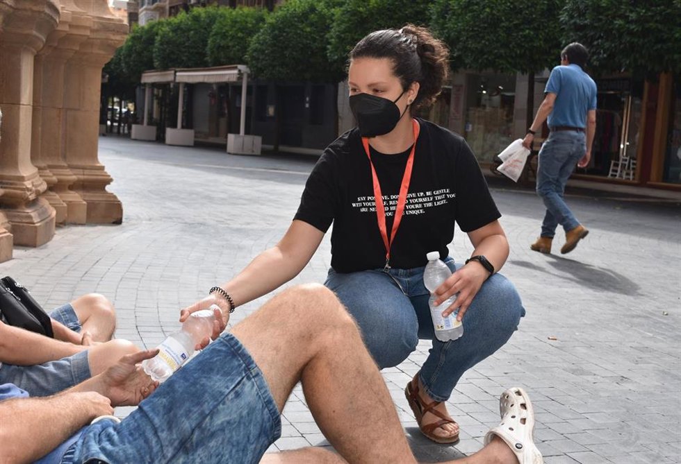 Una voluntaria de la Fundación reparte botellines de agua