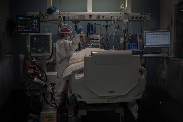 Archivo - Treballadors sanitaris protegits atenen un pacient a l'UCI 