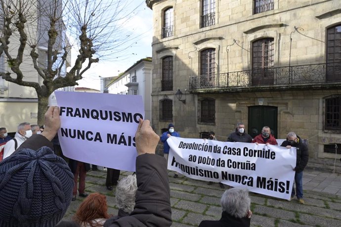 Archivo - Un hombre lleva un cártel en el que se lee, `Franquismo nunca más, junto a varias personas que se concentran frente a la Casa Cornide bajo el lema 'A Casa Cornide é da Coruña. Devolución, xa'.