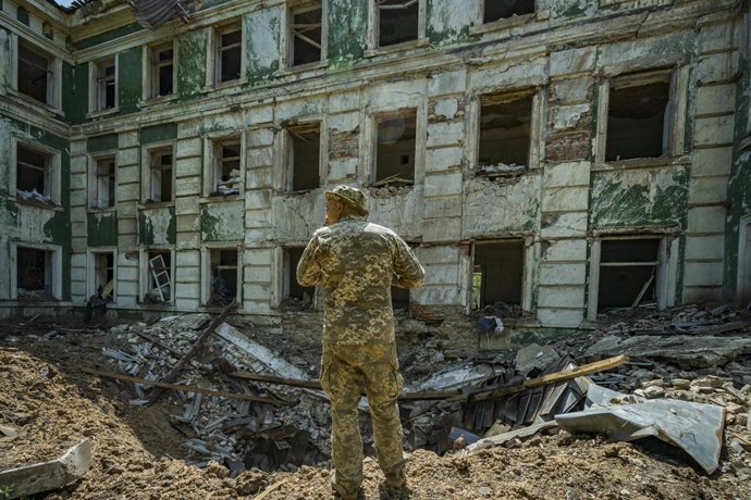 Un soldat ucrans comprova el crter després de l'impacte d'un coet rus sobre una escola secundria a Kostiantínivka, el Donbass