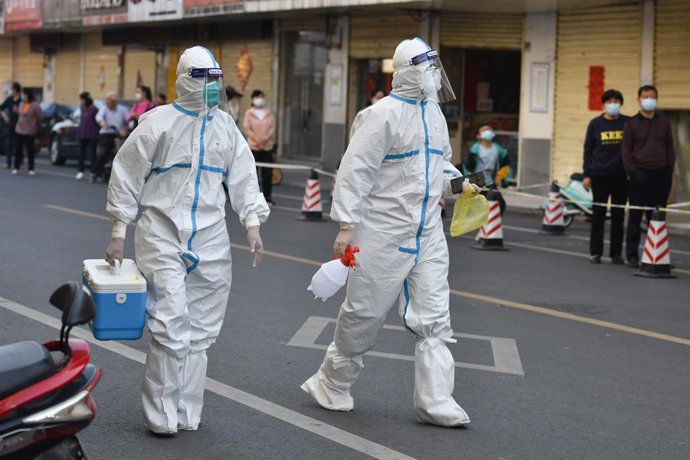 Archivo - 10 April 2022, China, Fuyang: Medical personnel in protective suits walk on a street, in a cordoned-off area in Fuyang. Mainland China reported 1,318 new confirmed local corona cases on Saturday 09 April, up from 1,334 on Friday, the National 