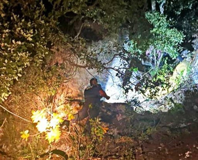 Un guardia civil desciende por el terraplén al que habían caído los dos senderistas