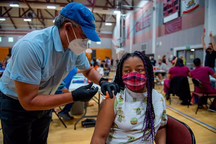 Una niña de 13 años recibe su primera dosis de la vacuna contra el coronavirus en un centro escolar de Sacramento.