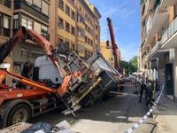 Una grúa vuelva sin heridos sobre otro camión en una calle estrecha de Retiro