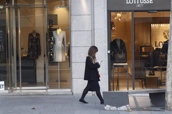 Archivo - Una mujer pasa por un centro comercial de Madrid en período de rebajas. 