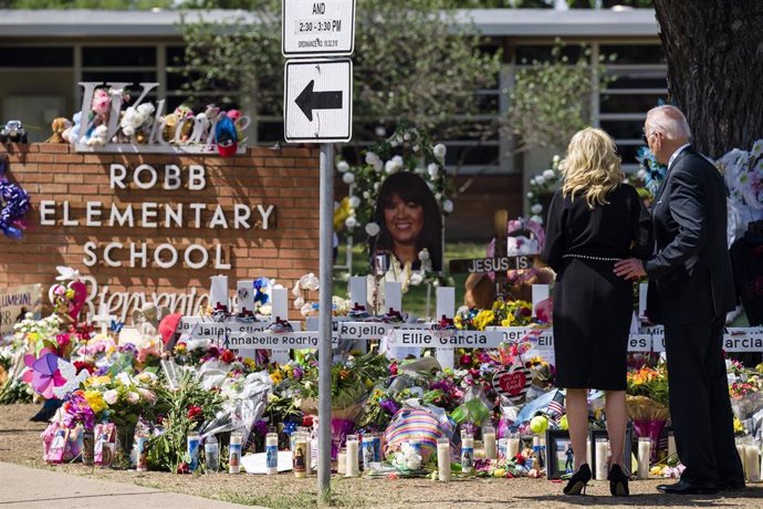 El presidente de EEUU, Joe Biden, y la primera dama, Jill Biden, depositan un ramo de flores durante una visita a un monumento en forma de cruz frente a la escuela primaria Robb, lugar donde se produjo un tiroteo masivo en el que el pistolero de 18 años