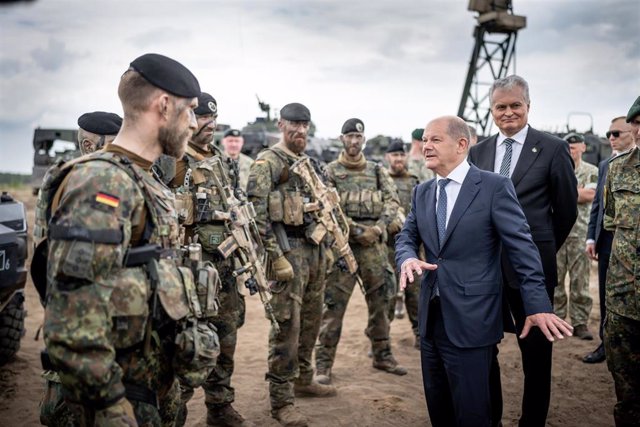 El canciller alemán, Olaf Scholz, junto a un grupo de soldados alemanes y el presidente de Lituania, Gitanas Nauseda, en el destacamento alemán en la cñiudad lituana de Pabrade.  