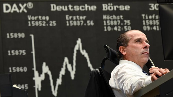 Archivo - 30 December 2021, Hessen, Frankfurt_Main: Securities trader Arthur Brunner of ICF Bank is on the phone at his desk on the floor of the Frankfurt Stock Exchange in front of the display board showing the Dax curve on he last day of trading in 20