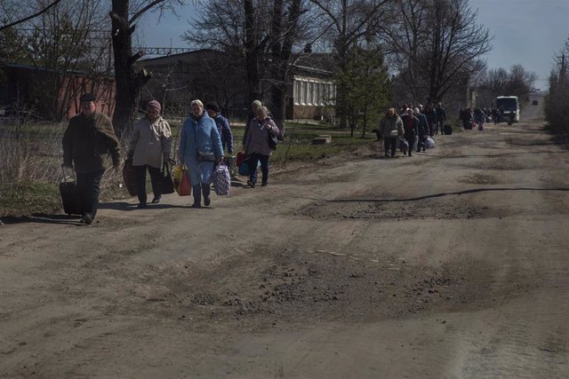 Archivo - Severodontesk, Ucrania: La gente camina a pie por un camino de tierra cuando el autobús no pudo seguir conduciendo después de ayudarles a evacuar en Severodontesk, Ucrania, el 7 de abril de 2022