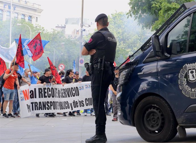 Un policía municipal vigila a los manifestantes durante una concentración de trabajadores de transporte público de Madrid frente al Ayuntamiento de Madrid.